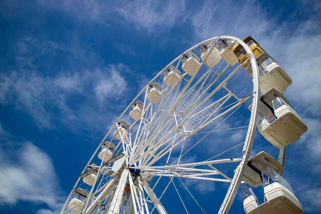 Ruota panoramica di colore bianco nel cielo blu