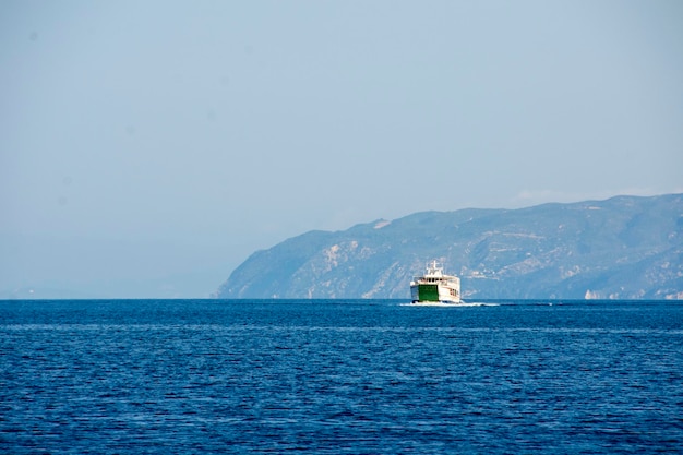 A ferry boat on the water with a mountain in the background