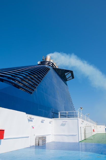 Ferry in the sea and smoke from the chimney against the blue sky Transport and travel concept