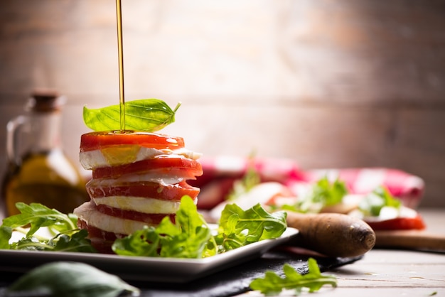 Fesh Italian Caprese salad with sliced mozzarella and herbs