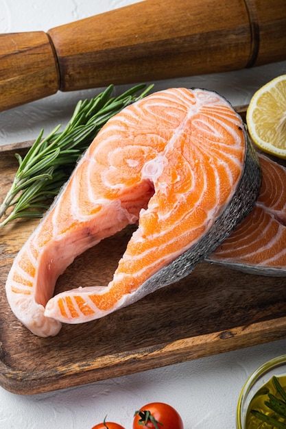 Fesh raw trout fillet with herbs over white background