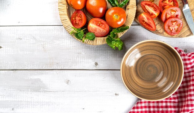 Fesh tomato with cooking set up isolated on light background