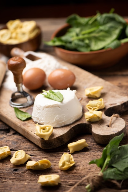 Fesh tortellini ravioli op houten rustieke tafel met spinazie en ricotta