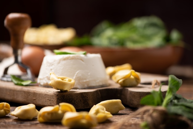 Fesh tortellini ravioli op houten rustieke tafel met spinazie en ricotta