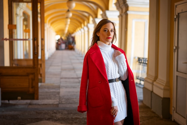 Feshion woman in a red jacket standing on the street