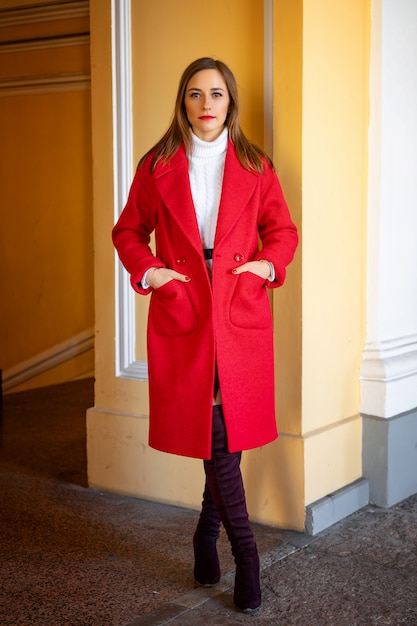 Feshion woman in a red jacket standing on the street