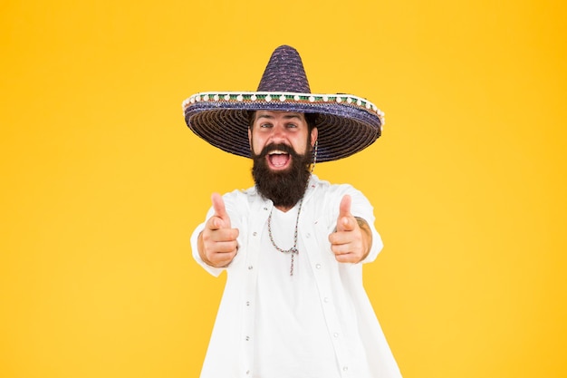 Fest and holiday Celebrate traditions hipster looks festive in sombrero celebrating fiesta happy man wear poncho having fun on mexican party sombrero party man man in mexican sombrero hat