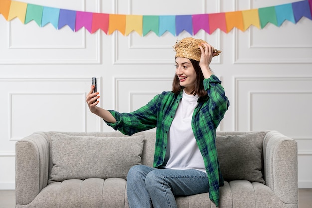 Festa junina adorabile ragazza con cappello di paglia che celebra la festa brasiliana prendendo selfie