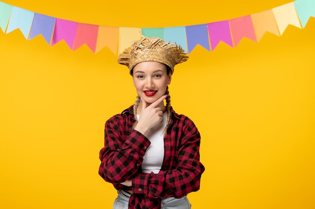 Festa junina blonde cute girl in straw hat brazilian festival with colorful flags holding chin