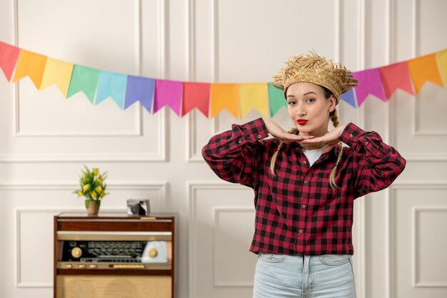 Festa junina schattig meisje in strohoed Braziliaanse midzomer retro radio kleurrijke vlaggen handen op kin