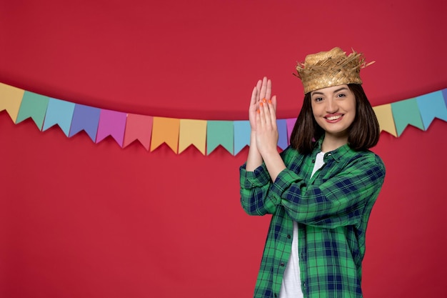 Foto festa junina in cappello di paglia bruna ragazza carina che celebra il festival brasiliano battendo le mani