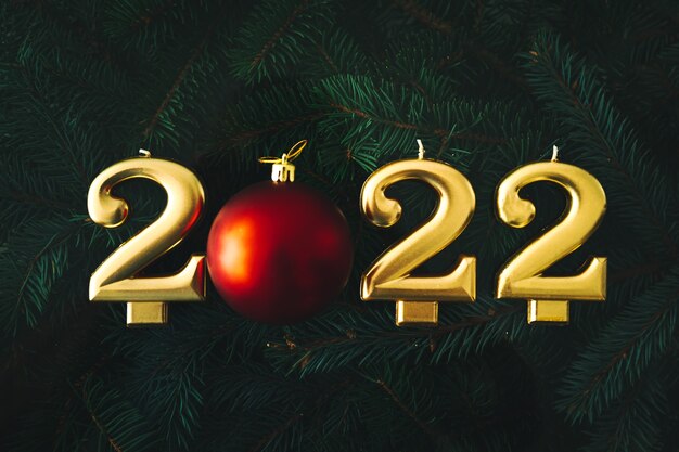 お祝いの背景明けましておめでとうございます2022年。モミの枝の背景に金のキャンドル。
