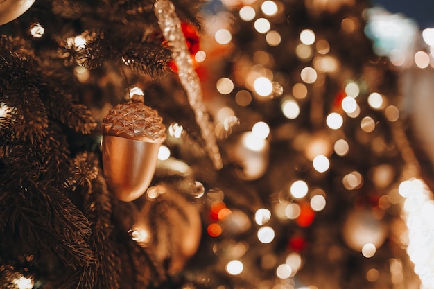 Festive background with beautiful Golden bokeh lights Christmas toy acorn fir branches