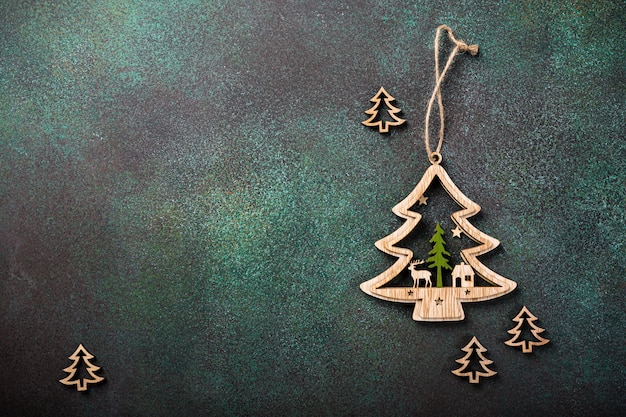 Festive background with wooden christmas tree and decoration. Copy space, winter holidays greeting card, flat lay, top view.