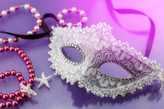 A festive, Beautiful white mardi gras or carnival mask on beautiful colorful paper