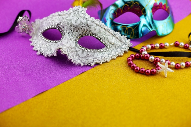 A festive,Beautiful white mardi gras or carnival mask on beautiful gold paper.