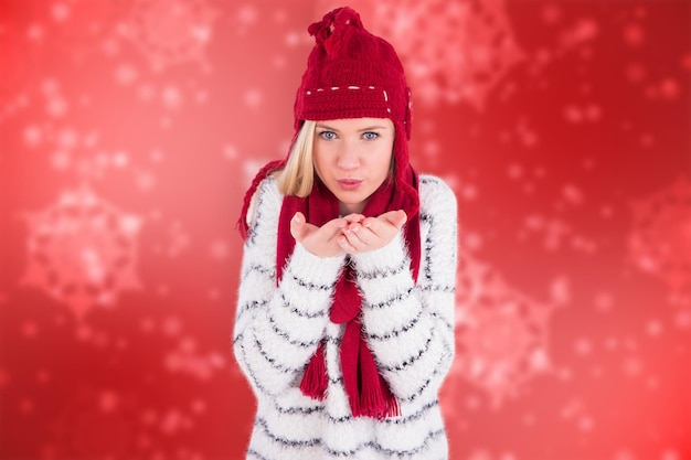 Festive blonde blowing over hands against digitally generated delicate snowflake design