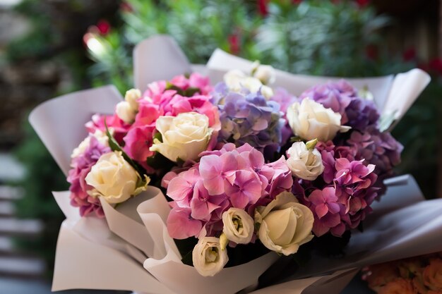 A festive bouquet of a bouquet of roses and hydrangeas in the rays of sunlight. Flower background