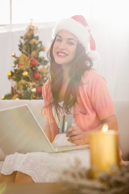 クリスマスのラップトップでオンラインでショッピングする茶色のお茶髪