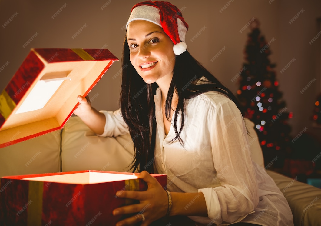 Premium Photo  Festive brunette opening a glowing christmas gift