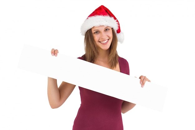 Праздничная брюнетка в шляпе Санта показывает пустой баннер