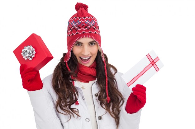 Festive brunette in winter clothes holding gifts