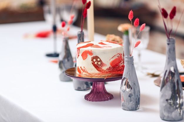 宴会テーブルに赤のお祝いケーキ。レストランのインテリア。