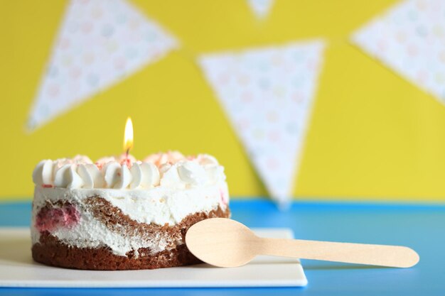 Photo festive cake with a birthday candle cake with a spoon cake on a festive background