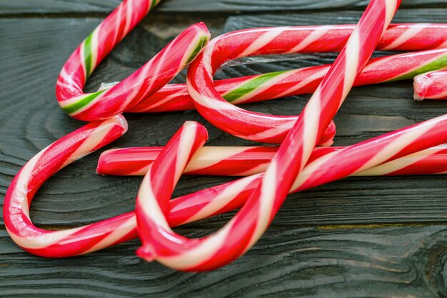 Festive caramel Christmas staffs lie heap on wooden surface. Concept of Christmas traditio