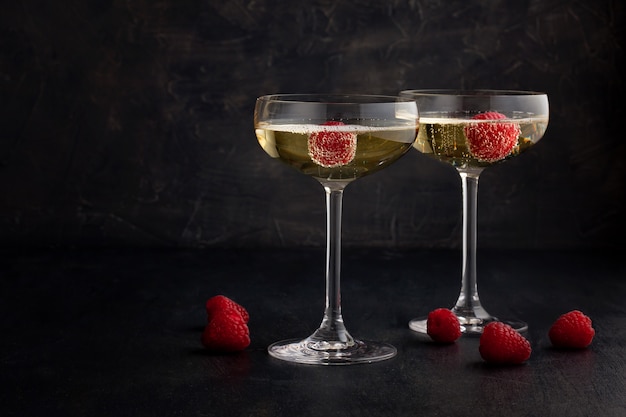 Festive champagne glasses with raspberries