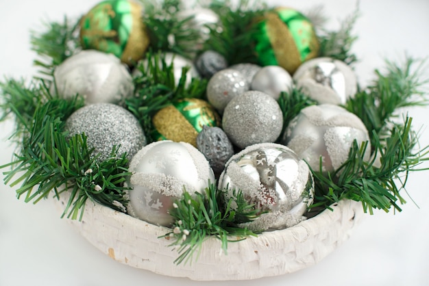 A festive Christmas arrangement artificial branches, glass balls in the basket.