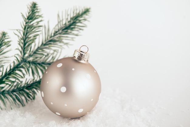 Festive christmas ball on white background with snow and fir branches