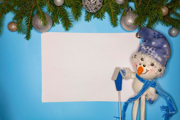 Праздничная рождественская открытка со снеговиком, рождественской безделушкой и еловыми ветками на зимнем фоне...