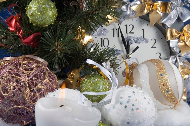 Festive Christmas composition with clock, various holiday balls candle and other adornments