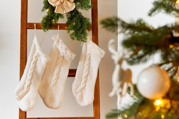 Festive Christmas decorations of a light room with a Christmas tree and knitted socks for Santa's gifts.