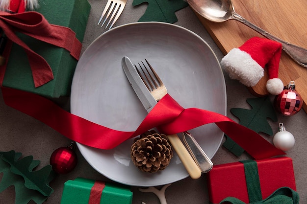 Cena di natale festivo sottofondo coperto con piatto e posate contornato da decori dec...