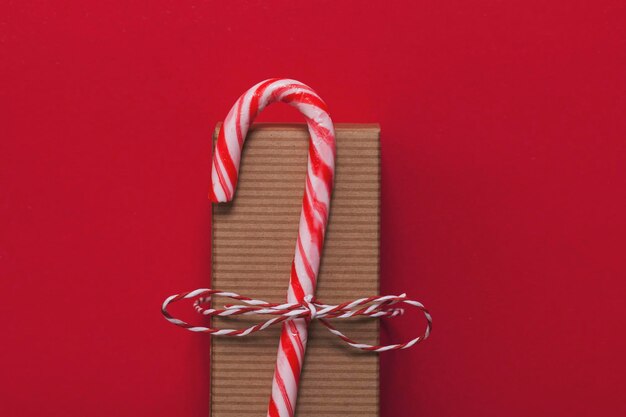 Festive Christmas present with candy cane on a red background