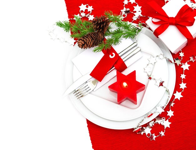 Festive christmas table place setting decoration in red and silver. candle light dinner. holidays background