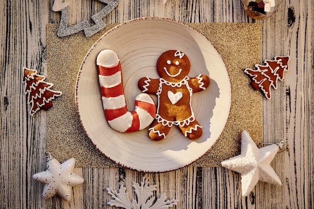Foto tavola di natale festiva che serve piatto beige con biscotti di pan di zenzero fatti a mano, decorazioni natalizie