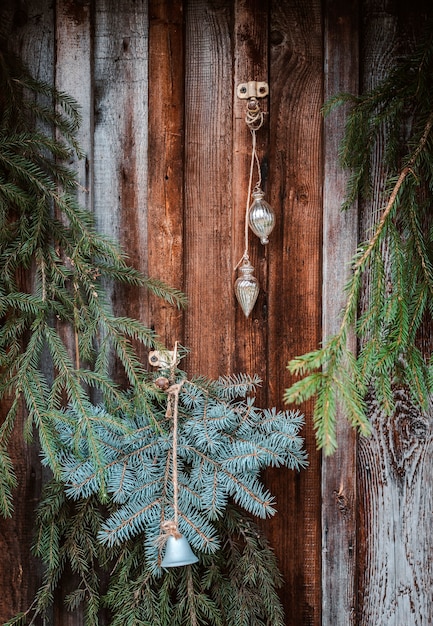 Festive christmas window decoration with fir branches, garlands and cones. Merry Christmas sign and baubles on the window sill