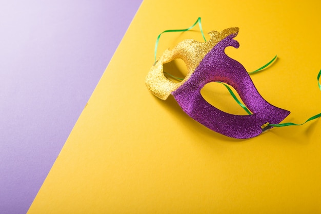 A festive, colorful group of mardi gras or carnivale mask on a yellow purple background. Venetian masks.