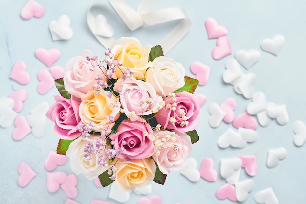 Photo festive composition with beautiful delicate roses flowers in pink round box on light blue background. flat lay, copy space. greeting card.