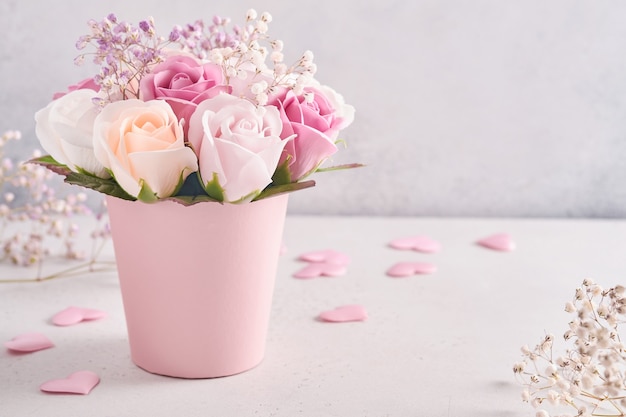 Festive composition with beautiful delicate roses flowers in pink round box on light gray background. Flat lay, copy space.