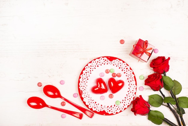 Festive concept for Valentines Day Appetizing icing hearts on a lacy napkin roses and gift box