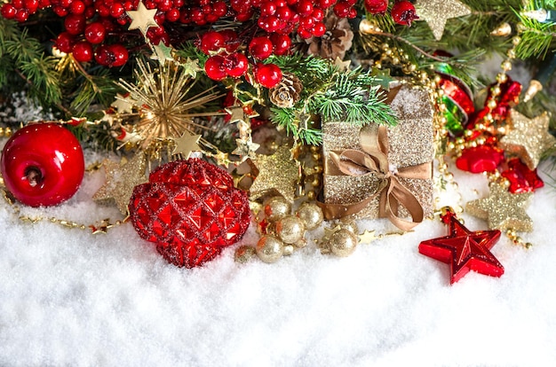 Festive decoration with baubles, golden garlands, christmas tree and red berries branches. holidays background