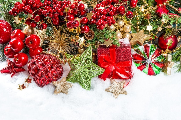 Festive decoration with baubles, golden garlands, christmas tree and red berries branches. holidays background