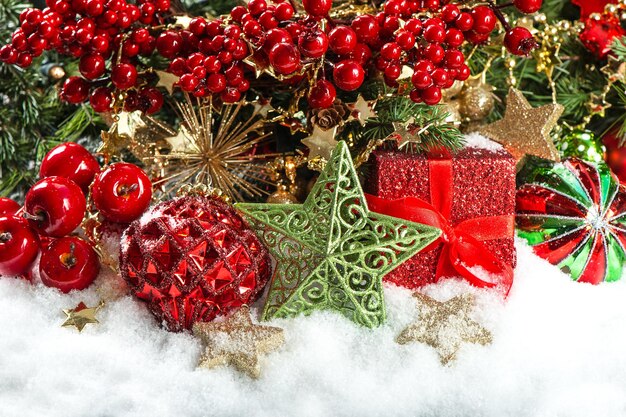 Festive decoration with baubles, golden garlands, christmas tree and red berries branches. holidays background