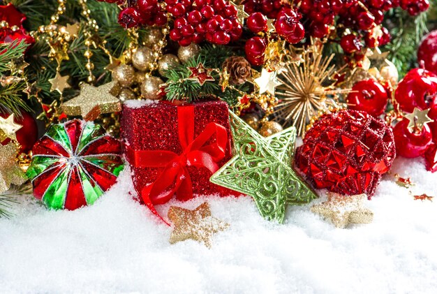 Festive decoration with baubles, golden garlands, christmas tree and red berries branches. holidays background