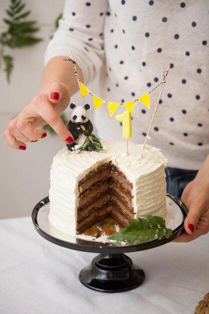 장난감 팬더와 깃발 배너로 장식된 생일 건강한 당근 케이크를 위한 축제 진미