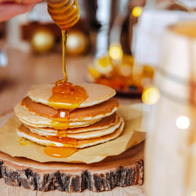 festive dessert table homemade cakes, pancakes with honey, pour honey on pancakes